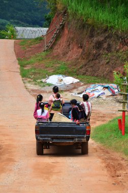 Taylandlı sürücüler sokak yolunda kamyonet kullanıyorlar yerel thai kabile ailelerini taşıyorlar ve çocuklar Phetchabun, Tayland 'da Phu Tub Berk' teki Baan Rong Kla Hill köyünde kırsal kesime gidiyorlar.