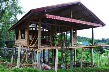 Asyalı işçiler ve Tayland 'da Phetchabun, Tayland' daki bir dağdaki inşaat alanında inşaat iskelesinde el yapımı el yapımı ve makineli alet kullanan işçiler inşa ediyorlar.