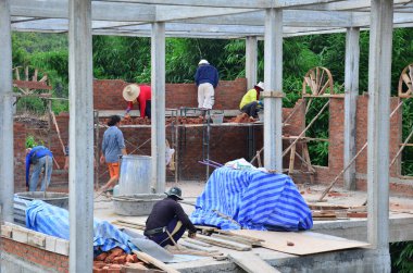 Asyalı işçiler ve Tayland 'da Phetchabun, Tayland' daki bir dağdaki inşaat alanında inşaat iskelesinde el yapımı el yapımı ve makineli alet kullanan işçiler inşa ediyorlar.