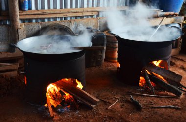 Tayland yerel şefi, Phetchabun, Tayland 'daki Phu Tub Berk Hill köyündeki mutfak odasında eski kömür kömürü kabilesi tarzında eski bir evde klasik retro tava ve haşlanmış et ve kemik domuz eti kullanır.