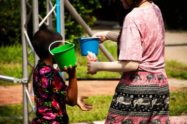 Taylandlı çocuklar, Taylandlı çocuklar, gezginler, gezgin çocuklar, gezgin çocuklar, gezici çocuklar. Songkran Festivali 'nde su sıçratma oyunu, fillerle su sıçratma, Tayland, Ayutthaya' da yeni yıl.