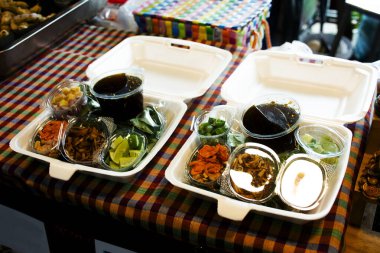 Geleneksel yerel Thai atıştırmalık tatlı Miang Kham veya kraliyet baharatlı yaprak dürümü yanında karamelli tatlı soslu aperatif insanlar için Bangkok, Tayland 'daki sokak pazarında içki satın alır.