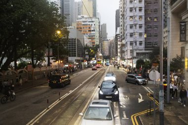 26 Nisan 2025 'te Hong Kong, Çin' de trafik yolunda gece vakti yürüyen Hong Kong şehrinin gökdelen şehir manzaralı evini, gece hayatını ve yerel Çin yaşam tarzını izleyin.
