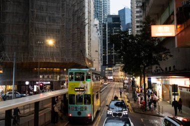 26 Nisan 2025 'te Hong Kong, Çin' de trafik yolunda gece vakti yürüyen Hong Kong şehrinin gökdelen şehir manzaralı evini, gece hayatını ve yerel Çin yaşam tarzını izleyin.