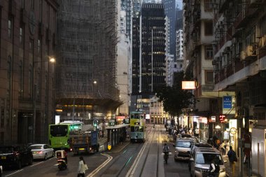 26 Nisan 2025 'te Hong Kong, Çin' de trafik yolunda gece vakti yürüyen Hong Kong şehrinin gökdelen şehir manzaralı evini, gece hayatını ve yerel Çin yaşam tarzını izleyin.