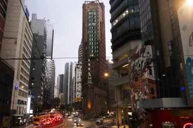 26 Nisan 2025 'te Hong Kong, Çin' de trafik yolunda gece vakti yürüyen Hong Kong şehrinin gökdelen şehir manzaralı evini, gece hayatını ve yerel Çin yaşam tarzını izleyin.