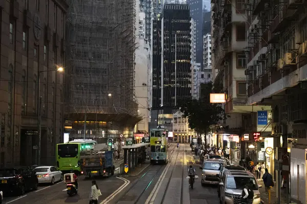 26 Nisan 2025 'te Hong Kong, Çin' de trafik yolunda gece vakti yürüyen Hong Kong şehrinin gökdelen şehir manzaralı evini, gece hayatını ve yerel Çin yaşam tarzını izleyin.