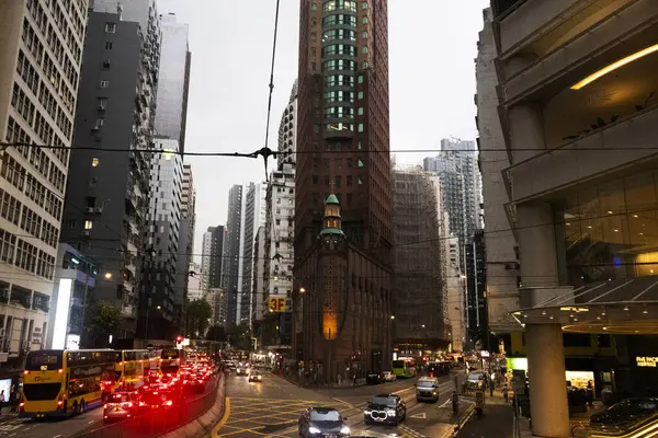 26 Nisan 2025 'te Hong Kong, Çin' de trafik yolunda gece vakti yürüyen Hong Kong şehrinin gökdelen şehir manzaralı evini, gece hayatını ve yerel Çin yaşam tarzını izleyin.