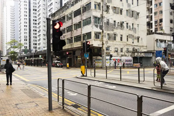 26 Nisan 2025 'te Hong Kong, Çin' de trafik ışıklarıyla caddede yürüyen Hong Kong şehrinin gökdelen manzaralı şehir manzaralı evini ve yaşam tarzını izleyin.