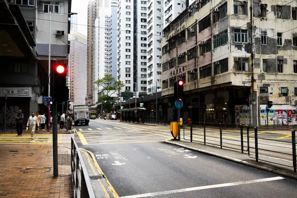 26 Nisan 2025 'te Hong Kong, Çin' de trafik ışıklarıyla caddede yürüyen Hong Kong şehrinin gökdelen manzaralı şehir manzaralı evini ve yaşam tarzını izleyin.