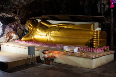 Antik Buda, Tayland 'da, Phetchaburi' de, Tayland 'da bulunan Wat Khao Bandai Tapınağı' ndaki antik mağara tünelinde seyahat eden gezginler için kutsal ve gizemli bir melek kutsaması için dua edin.