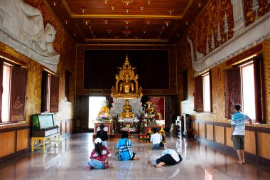 Taylandlı gezginler için antik Buda heykeli. 28 Haziran 2025 'te Tayland, Phetchaburi' de, Ban Laem 'deki Wat Nok Pak Thale Tapınağı' nda kutsal ibadeti kutsa.