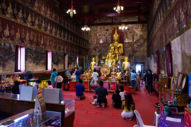 Taylandlı gezginler için antik altın Buda heykeli. 28 Haziran 2025 'te Tayland, Phetchaburi' de, Wat Mahathat Worawihan Tapınağı 'nda kutsal ibadeti kutsa.