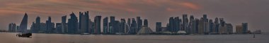 Corniche 'den Doha Skyline günbatımı panoramik manzara West Bay gökdelenlerini gösteriyor