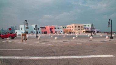 Old Doha port (Mina District) in Doha, Qatar afternoon shot showing cafe, restaurants and cruise ships with locals and visitors walking