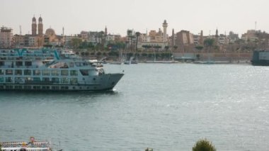 Luxor, Mısır 'ın güneş ışığı batıdan yaklaşırken Nil Nehri' nin doğu yakasında Feluccas ve Luxor Tapınağı adlı yolcu gemileriyle çekildiğini gösteriyor.