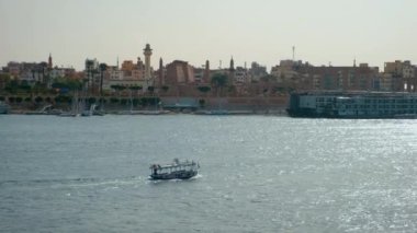 Luxor, Mısır 'ın güneş ışığı batıdan yaklaşırken Nil Nehri' nin doğu yakasında Feluccas ve Luxor Tapınağı adlı yolcu gemileriyle çekildiğini gösteriyor.