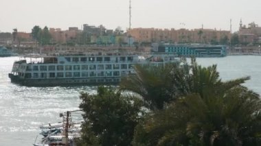 Luxor, Mısır 'ın güneş ışığı, arka planda Nil Nehri' ni yolcu gemileri, Feluccas ve Doğu Kıyısı ile gösteren batı kıyısından zumluyor.