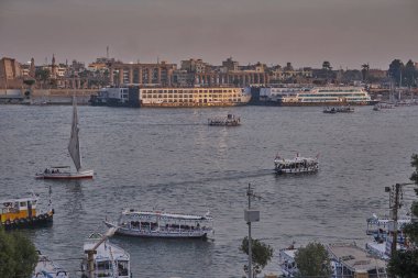 Luxor ,Egypt sunset shot from west bank showing Nile river with  Feluccas, cruise ships  and Luxor Temple in East bank
