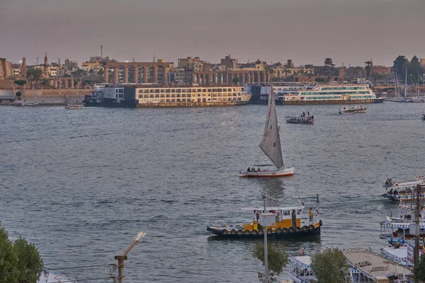 Luxor ,Egypt sunset shot from west bank showing Nile river with  Feluccas, cruise ships  and Luxor Temple in East bank
