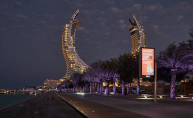 Katara Hospitality Tower, or Lusail Katara Hotel North Tower in Lusail, Qatar at dusk showing the unique architecture of the illuminated tower