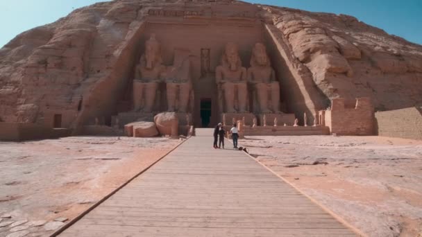 在埃及阿布辛贝尔阿斯旺的阿布辛贝尔圣殿外日光拍摄 展示拉马斯二世大圣殿 游客在主入口 — 图库视频影像