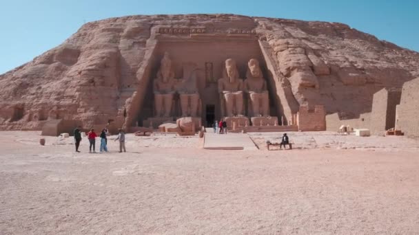 在埃及阿布辛贝尔阿斯旺的阿布辛贝尔圣殿外日光拍摄 展示拉马斯二世大圣殿 游客在主入口 — 图库视频影像