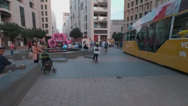 카타르 도하의 므셰어렙 다운타운에서 오후에 방문객들이 전차의 독특한건 축물을 사진을 — 비디오