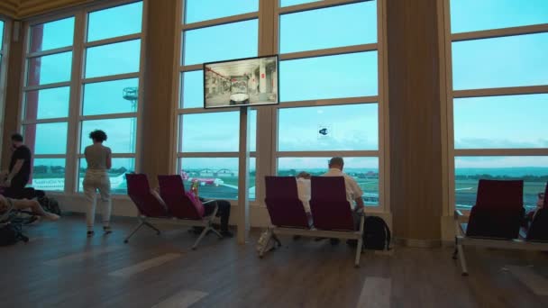 バリ島ヌグラライ国際空港またはデンパサール空港とも呼ばれます 出発ゲートで待っている乗客を示すインテリアショット — ストック動画
