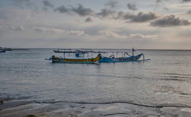 Kuta 'daki Pantai Jerman (Alman Sahili), Bali Endonezya' da günbatımı. Okyanusta kayıkları gösteren bir çekim.