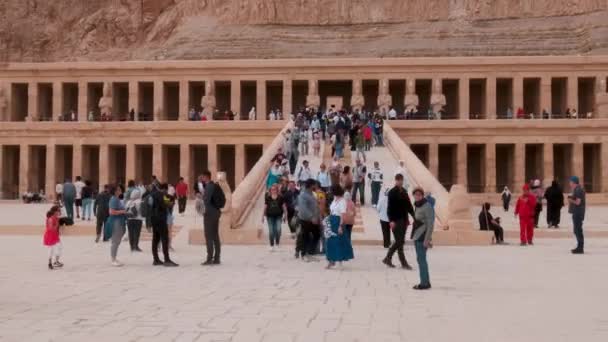 エジプトの18世紀のファラオ ハトシェプストの治世中に建てられたハトシェプストの霊廟 入り口の観光客との外部の日照ビュー — ストック動画