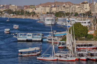 Nile river in Aswan, Egypt afternoon shot showing feluccas and boats in the river with elephantine Island (UNESCO World Heritage site)