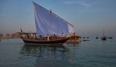 Katara13. Katar geleneksel dhow festivali Doha Katar Günbatımı Çekimi katılımcı ülkelerin bayraklarıyla Arap Körfezi 'nde geleneksel dhowları gösteriyor.