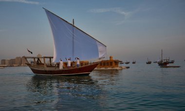 Katara13. Katar geleneksel dhow festivali Doha Katar Günbatımı Çekimi katılımcı ülkelerin bayraklarıyla Arap Körfezi 'nde geleneksel dhowları gösteriyor.