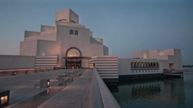 İslam Sanatları Müzesi Doha, Katar 'ın gün batımı dış çekimi müzenin ana girişini yürüyen insanlarla gösteriyor.