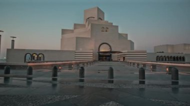İslam Sanatları Müzesi Doha, Katar 'ın gün batımı dış çekimi müzenin ana girişini yürüyen insanlarla gösteriyor.