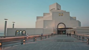 İslam Sanatları Müzesi Doha, Katar 'ın gün batımı dış çekimi müzenin ana girişini yürüyen insanlarla gösteriyor.