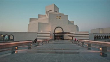 İslam Sanatları Müzesi Doha, Katar 'ın gün batımı dış çekimi müzenin ana girişini yürüyen insanlarla gösteriyor.