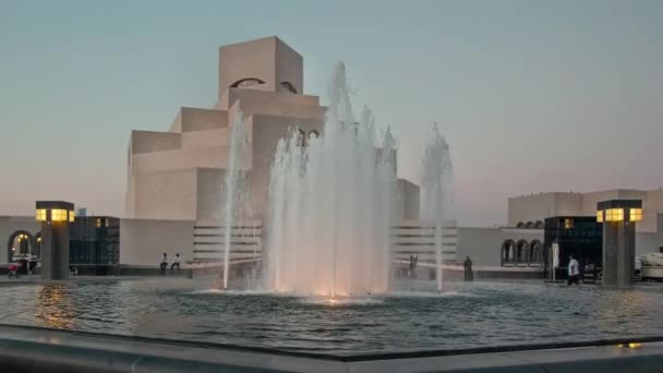 イスラム美術館 カタールのサンセット外観ショット前景の噴水と車と人々が歩く背景にある博物館へのメインエントランス — ストック動画