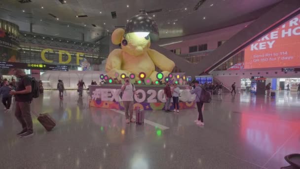 ハマド国際空港の出発ホール ドーハ 夜にカタール スイスのアーティストウルスフィッシャーと エキスポ2023 Dohaによる大きなランプ熊像を示す — ストック動画