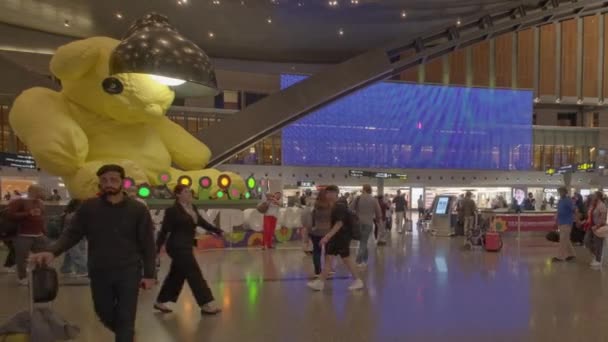 ハマド国際空港の出発ホール ドーハ 夜にカタール スイスのアーティストウルスフィッシャーと エキスポ2023 Dohaによる大きなランプ熊像を示す — ストック動画
