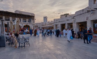 Souq Waqif, Doha, Katar ana caddesinde 2023 AFC Asya Kupası sırasında Arap Tekstil Dükkanı, Kafe, yerli ve yürüyen ziyaretçileri gösteriyor..