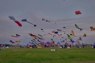 Doha, Katar - 31 Ocak 2024: Katar Kite Festivali 2024 Eski Doha Limanı 'nda (Mina Bölgesi) renkli uçurtmaların muhteşem bir şekilde gökyüzünde süzüldüğünü gösteren gece çekimi. 