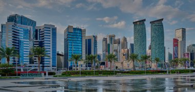 Doha silueti batı körfezi bölgesinde Doha, Katar öğleden sonra otelin parkından çekildi ön planda yapay göl ve arka planda bulutlar