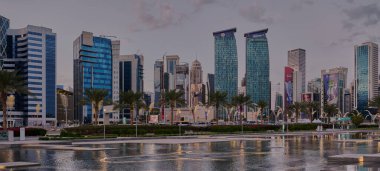 Doha, Katar - 2 Şubat 2024: Batı Körfezi 'ndeki Doha silueti öğleden sonra otelin parkından ön planda yapay göl ve arka planda bulutlarla çekildi