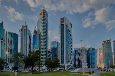 Doha, Katar - 2 Şubat 2024: Batı körfezi bölgesindeki Doha silueti öğleden sonra Şeyh Tamim Bin Hamad Al-Thani Uluslararası Yolsuzlukla Mücadele Mükemmellik Ödülü anıtı ile otelin parkından çekildi
