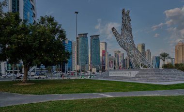 Doha, Katar - 2 Şubat 2024: Batı körfezi bölgesindeki Doha silueti öğleden sonra Şeyh Tamim Bin Hamad Al-Thani Uluslararası Yolsuzlukla Mücadele Mükemmellik Ödülü anıtı ile otelin parkından çekildi