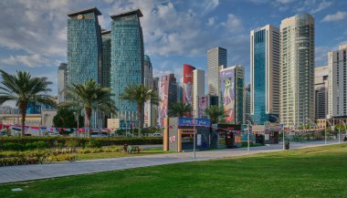 Doha, Katar - 2 Şubat 2024: Doha silueti Batı körfezi Doha, Katar gün batımı manzaralı AFC Asya Kupası Katarı 2023 'ün maskotları gökyüzündeki binalar ve bulutlar