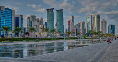 Doha silueti batı körfezi bölgesinde Doha, Katar öğleden sonra otelin parkından çekildi ön planda yapay göl ve arka planda bulutlar