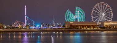 Al Maha Adası 'ndaki Lusail Kış Harikalar Diyarı eğlence parkı. Lusail şehri, Katar. Dönme dolabı gösteren uzun pozlu gece çekimi..